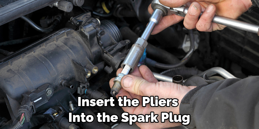  Insert the Pliers Into the Spark Plug